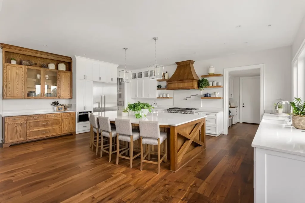 New kitchen with white and wood grain cabinets as well as a hardwood floor.